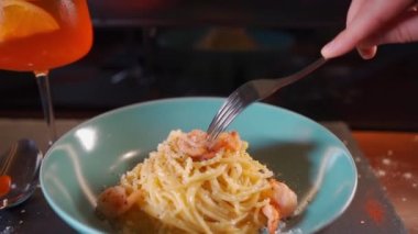 İnsan İtalyan carbonara makarnası yer deniz ürünleri, karides, aperol spritz cam