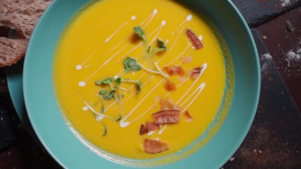 Abóbora amarela fresca ou sopa de creme de ervilhas com bacon e verde — Vídeo de Stock