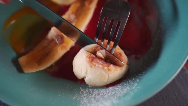 Persona comer panqueque de queso con plátano y mantequilla de maní, mango, salsa de frambuesa — Vídeo de stock