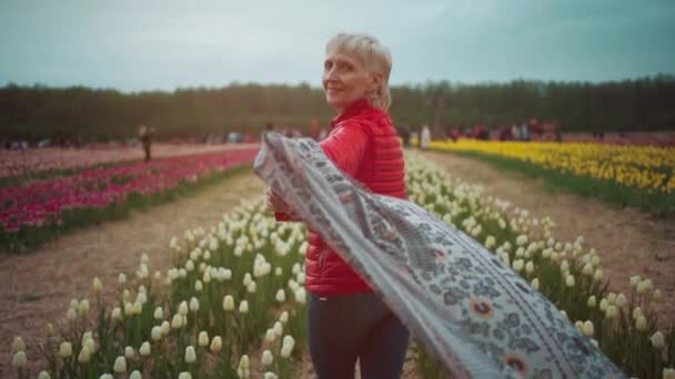 Szczęśliwy piękny starszy kobieta spacery i zabawy na kwiat tulipan festiwal — Wideo stockowe