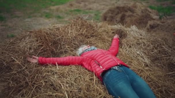 Wanita tua yang bahagia menikmati hidup dan bersantai di lapangan jatuh di atas jerami — Stok Video