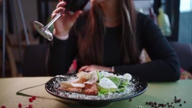 Dişiler taze sezar salatasını marul, tavuk ve kırmızı şarapla yerler.