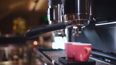 Barista kahve hazırlıyor. Kahve fincanda ve profesyonel makineyle.