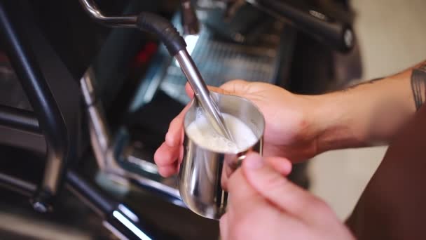Barista verwarmen verse melk voor het maken van cappuccino of latte koffie warme drank — Stockvideo