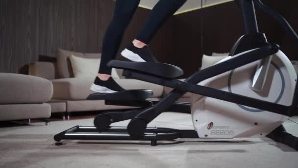 Menutup kaki wanita berjalan pada mesin pengorbit elips di gym kebugaran — Stok Video