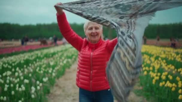 Glücklich schöne Seniorin zu Fuß und haben Spaß auf Blume Tulpenfest — Stockvideo