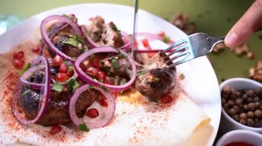 Gürcistan usulü kızarmış domuz sosisi ve soğan ve kişniş yemeye yakın çekim.