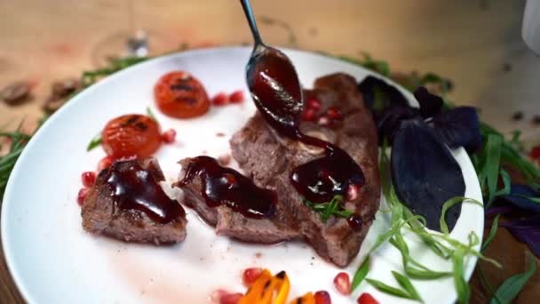 Adicionando molho no bife grelhado de carne de ribeye com ervas na placa branca no restaurante — Vídeo de Stock