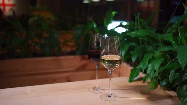 Gros plan de vin rouge et blanc géorgien élégant en verre sur la table du restaurant — Video