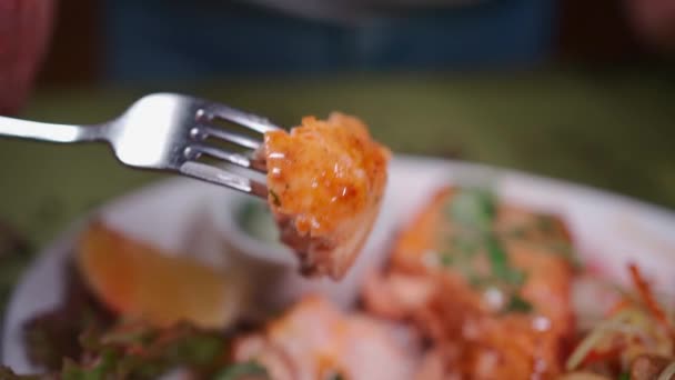 Gros plan à la main avec une fourchette trempant le steak de saumon rôti dans la sauce ou mangeant du poisson — Video