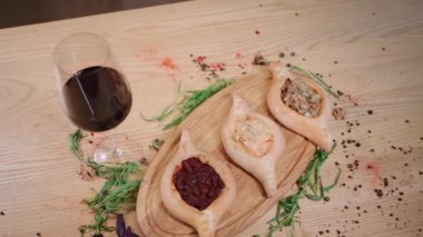 Restoran masasında mantar, somon ve fasulye bulunan Gürcü Adjarian Khachapuri.