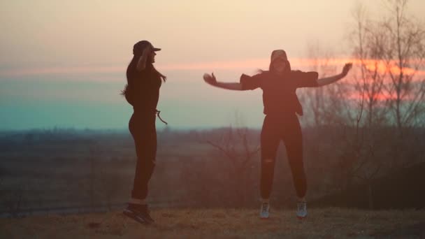 Deux athlètes féminines font de l'exercice physique et de l'exercice en plein air au coucher du soleil — Video