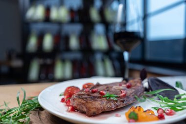 Baharatlı biftekli ızgara biftek ya da restoran masasında beyaz tabakta bitki.