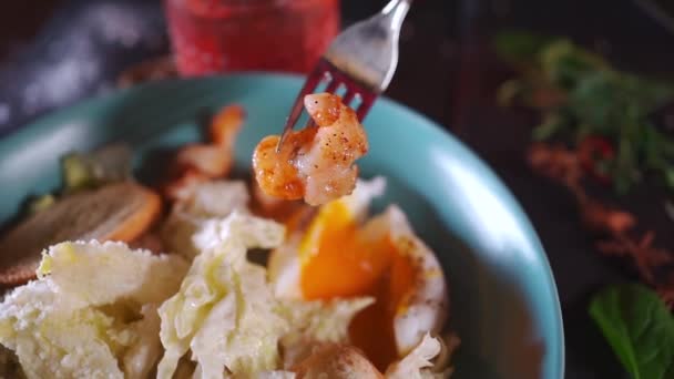 Personne manger salade césar aux crevettes, laitue, oeuf poché, crouton — Video