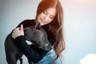 Güzel Ukraynalı kadın evde köpekle oynuyor.