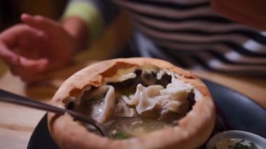Hamur köftesiyle et suyu ve hamur kabuğunda kişniş yemek.