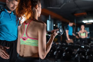 Çekici kadın beden eğitimi hocasıyla antrenman yapıyor.