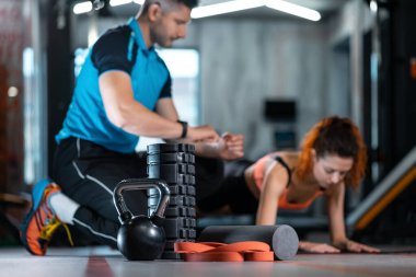 Sportif kadın spor salonunda koçla antrenman yapıyor.