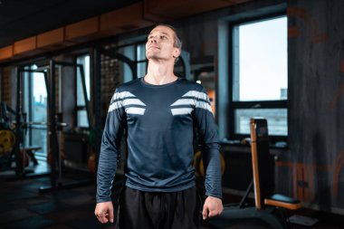 Spor salonunda egzersiz yapmadan önce yakışıklı erkek fitness eğitmeni.