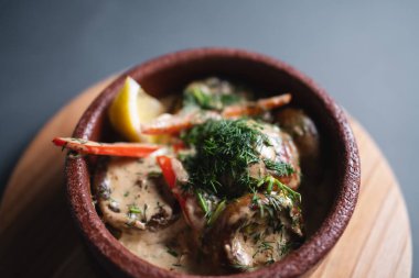 Peynir soslu ve tahta tabakta dolma biberli Champignon 'un yakın çekimi.