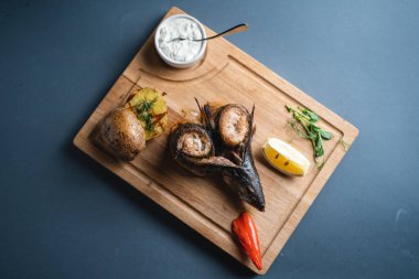 Fırında uskumruya yakın ya da arka planda sebzeli ızgara balık.