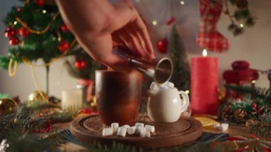 barman makes warm delicious cacao mug with sweets on wood board at new year eve