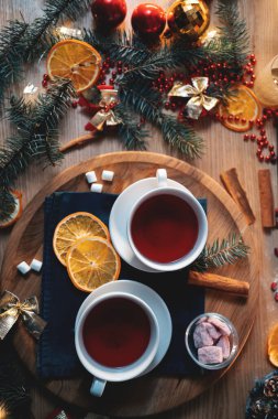 couple of mugs with traditional raspberry tea at new year eve, top view flatlay