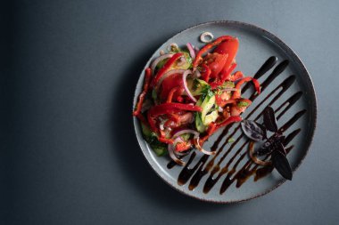 Biberli vejetaryen salatası, domates, salatalık, kırmızı soğan, siyah arka planda dereotu ve balzamik sos, restoran yemeği.