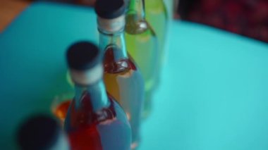 various colorful alcoholic drinks with shooters and transparent bottles
