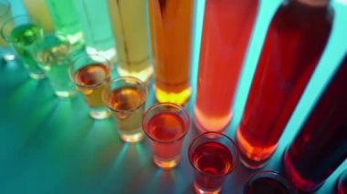 various colorful alcoholic drinks with shooters and transparent bottles