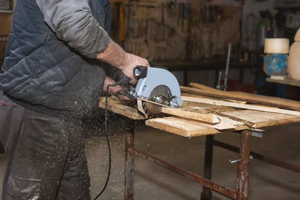 Κοντινό πλάνο ενός ξυλουργού που δουλεύει με δισκοπρίονο. Ο ξυλουργός πριόνι ξύλινα μπλοκ και πλάκες ξύλου — Φωτογραφία Αρχείου