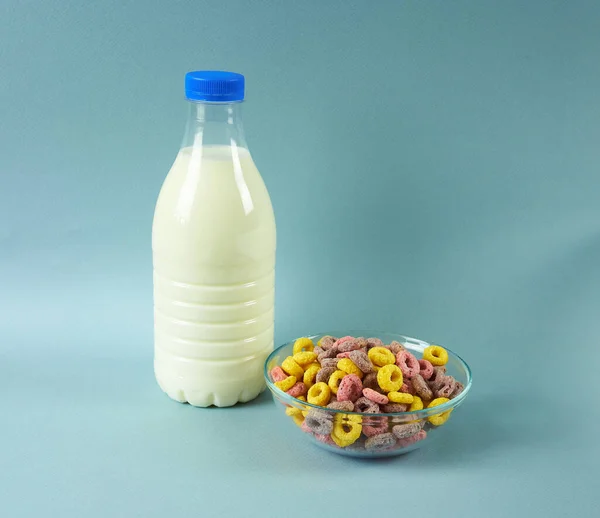 Бутылка Молока Тарелка Зерновых Колец Синем Фоне — стоковое фото