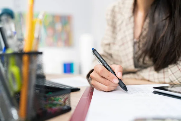 Bir belgeye, istatistiksel tabloya, şirket hesaplamalarına yakın çekim, bir ofis muhasebecisi doğru yerleri doldurmak, doğruluğu kontrol etmek, kağıda kalemle dokunmak.