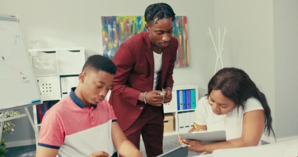 Escola moderna, forma de naukim, ensino remoto, usando dispositivos eletrônicos em sala de aula, resolvendo tarefas no computador, o professor explica a resposta correta para o menino, eles falam sobre ciência. — Vídeo de Stock