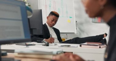 Koyu tenli rahat bir patron, ayakları masanın üzerinde oturmuş elinde tabletle internette dokümanlarda geziniyor iş arkadaşı sekreteriyle konuşuyor ve şakalar yapıyor..