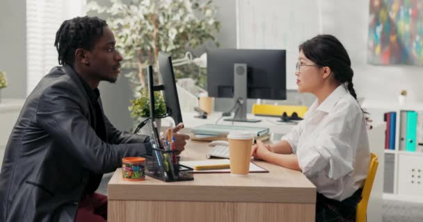 Head of company in elegant shirt and glasses with Asian beauty talks to candidate for team leader position, dark-skinned man answers questions, job interview shaking hands thanking for meeting goodbye — Stock Video