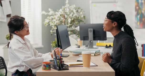 Les femmes s'assoient au bureau en face de l'autre entretien d'emploi sujet de langage commun pour les commérages patron à la peau foncée rit avec le candidat à un poste dans le bureau de l'entreprise serrer la main comme signe d'accord. — Video