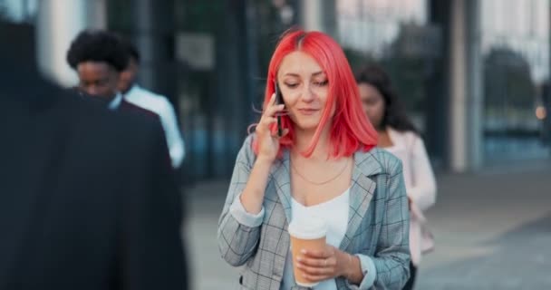 Na konci práce v kanceláři korporace, šéf tajemnice podnikatelka vyjde z moderní budovy drží šálek kávy, aby vzal pryč obdrží hovor rozhovory na telefonu — Stock video