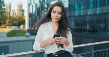 Şirkette çalışan güzel, güler yüzlü kadınlar ara vermek için dışarı çıkarlar şık kıyafetler içinde cam binanın önündeki korkuluklara yaslanarak ellerinde telefonla kahkahalar atarak haberleri okurlar.