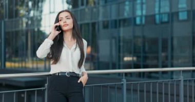 Arama yapmak, numarayı aramak, arkadaşlarını aramak, zarif genç bir kadının sevdiklerini aramak işten çıkmış bir iş kadını cam şirketinin önünde duruyor.