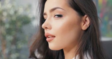 Çekici, güzel, güzel, şık giyinmiş bir kadının, iş kadınının, menajerin, müdürün, patronun yüzüne yakın çekim, günlük makyajla boyanmış, uzun kahverengi saçlı, koyu renk gözlü.