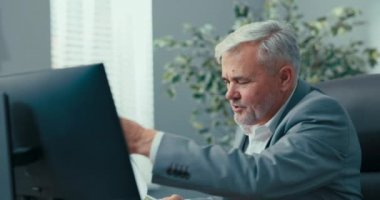 Şirketin gri saçlı başkanı, başkanın rahat koltuğunda oturuyor, ona sunulan belgeleri gözden geçiriyor, dikkatle okuyor, video konferansı sırasında meslektaşından çizelgeleri açıklamasını istiyor.