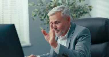 Şirketin başkanı, gri saçlı, zarif ceketli yaşlı bir adam, internet üzerinden uzak bir konferans düzenliyor, bir video kamera kullanarak, belgeleri, istatistikleri ve başarıları sunuyor.