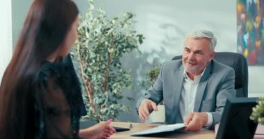 Şirketin olgun patronu yeni bir çalışanla sözleşme imzaladı. Şirket sekreter yardımcılığı için bir aday. Genç bayanın sözleşmesini ve diğer kızların elini sıkarak kutluyor.