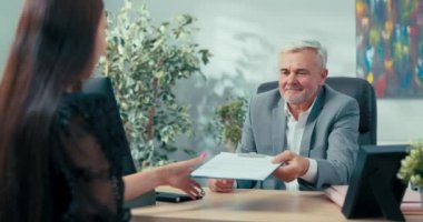 Şirketin olgun patronu yeni bir çalışanla sözleşme imzaladı. Şirket sekreter yardımcılığı için bir aday. Genç bayanın sözleşmesini ve diğer kızların elini sıkarak kutluyor.