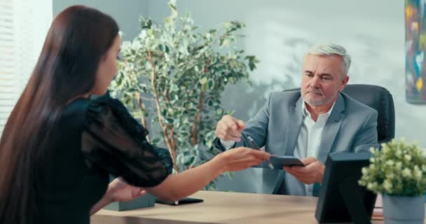 Candidat au poste de secrétaire du patron de l'entreprise est à un entretien d'embauche, une jeune fille signe un contrat pour une période indéterminée, donne au gestionnaire le document à signer — Video