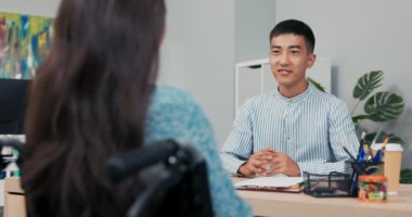 Gömlekli adam elinde kağıtlarla masanın arkasında oturuyor, patron görünmez tekerlekli sandalyedeki kadına sorular soruyor, engelli kızı sekreter olarak işe alıyor, kontrat okuyor, bilgisayardaki kadın verilerini kontrol ediyor.