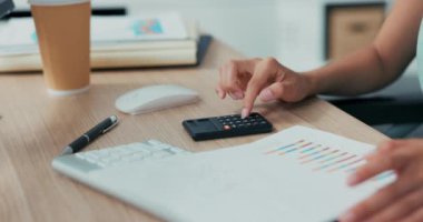 Şirketteki ahşap masanın yakın plan görüntüsü, hesap makinesi yalanları, kağıtlar, belgeler, sekreter, muhasebeci düğmelere basıyor, rakamları sayıyor, gelir ve karı hesaplıyor, çalışanların maaşlarını hesaplıyor