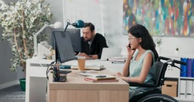 Engelli kadın muhasebe, sigorta, bir şirkette sekreter olarak çalışıyor, telefonla konuşuyor, randevular ayarlıyor, programlar ayarlıyor, müşterileri dinliyor, bilgi sağlıyor.