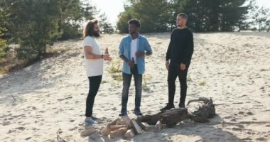 Üç adam sahilde duruyor, dışarıda, önlerinde odunlar uzanıyor, kamp ateşi için bir dal, erkekler konuşuyor, birbirlerini tanıyorlar, cam şişelerden bira içip tartışıyorlar.